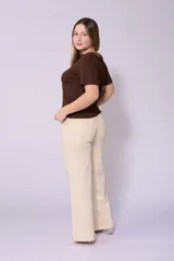 Jean de corte wide leg en color beige, con tiro alto y cierre frontal con botón y cremallera. Presenta un diseño de cinco bolsillos y costuras reforzadas.