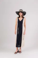 Vestido largo de lino con diseño bicolor en negro y beige. Presenta escote en V, breteles regulables y tajos laterales. Incluye detalles de bordados geométricos en el panel frontal central.