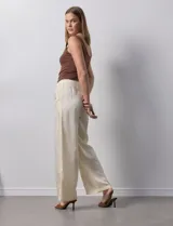 Pantalón palazzo color crudo de lyocell marca Nanette, con pretina elastizada, lazo de ajuste y bolsillos delanteros.