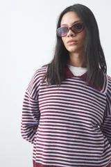 Sweater de punto a rayas horizontales en color bordó y celeste, con cuello polo y mangas largas con puños amplios. Presenta un diseño de calce relajado.