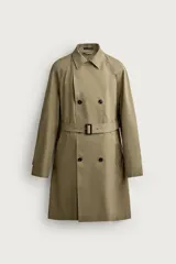 Trench regular fit de color beige, confeccionado en tejido técnico repelente al agua, con diseño de botonadura cruzada, cuello con solapas, mangas raglán con trabillas ajustables en los puños y cinturón del mismo tejido.