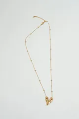 Collar dorado con cadena de eslabones pequeños y dije en forma de corazón con textura irregular.