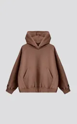 Hoodie oversize de corte crop en color marrón, confeccionado en frisa gamuzada de algodón. Presenta capucha forrada, bolsillo tipo canguro frontal y puños y ruedo acanalados.