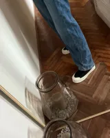 Zapatillas urbanas de lona color beige con cordones blancos y suela de goma blanca con diseño geométrico.