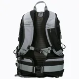 Mochila técnica de 22 litros marca Merrell, diseñada para actividades outdoor. Presenta un diseño bicolor en gris y negro, con múltiples compartimentos, bolsillos laterales para botellas, respaldo acolchado con malla transpirable, cinta frontal tipo daisy chain para accesorios y correas ajustables con silbato de emergencia.