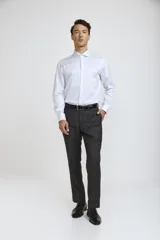 Camisa de vestir blanca de corte clásico, con cuello rígido, cierre frontal de botones y mangas largas con puños abotonados.