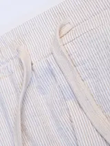 Pantalón celeste a rayas verticales blancas, de corte recto, con cintura elástica y cordón ajustable.