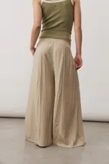 Pantalón ancho color marrón con cintura elástica y bolsillos laterales.