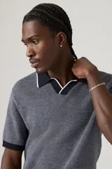 Sweater de punto gris con cuello polo negro con borde blanco, mangas cortas y corte slim.