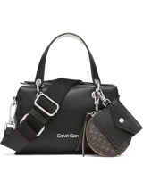 Cartera de mano y bandolera Calvin Klein, confeccionada en material sintético granulado color negro. Presenta doble asa superior, correa de hombro ajustable y extraíble, cierre principal con cremallera y logo de la marca en el frente. Incluye un accesorio colgante doble compuesto por un monedero circular con monograma y un pequeño estuche tipo sobre.