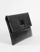 Sobre plegable de cuero vegano con diseño minimalista y abertura superior integrada. Incluye correa removible para usar como bandolera.