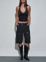 Bermuda de denim negro tipo cargo, con múltiples bolsillos con solapa en los laterales y cierre frontal con doble botón.