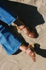 Sandalias de cuero color marrón, estilo huarache, con puntera cerrada de corte almendrado, tira ajustable con hebilla en el tobillo y taco cuadrado bajo con acabado símil madera.
