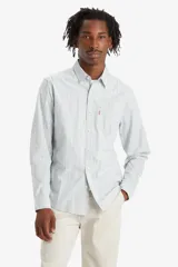 Camisa de hombre de manga larga a rayas verticales celestes y blancas, con bolsillo en el pecho y logo de la marca en rojo.