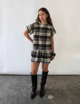 Vestido corto de corte recto con estampado de cuadros escoceses, cuello semi-alto, mangas cortas y detalle de volado en el ruedo.