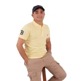 Remera tipo polo color amarillo con cuello clásico y logo bordado en el pecho. Corte recto y mangas cortas.