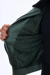 Campera de nylon color negro con cierre frontal, puños y ruedo elásticos, y cuello con forro de corderito sintético.