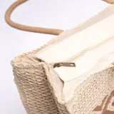 Bolso tipo shopper de yute color beige con diseño geométrico marrón en el centro. Asas cortas de soga.