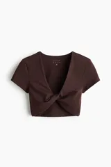Remera deportiva cropped H&M Move en tejido funcional marrón, con mangas cortas, escote en V y detalle de nudo girado en el frente.