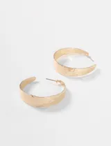 Par de caravanas tipo argolla, color dorado, con textura martillada y cierre de perno.