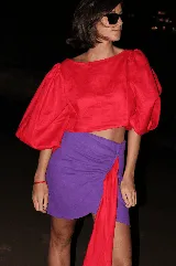 Falda corta de lino con lurex negro y plateado, de diseño cruzado estilo pareo con cierre invisible lateral y detalle de lazo asimétrico.