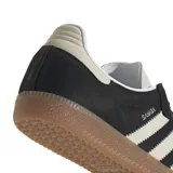 Zapatillas Adidas Samba OG negras con puntera color crema, las tres tiras laterales en color crema y suela de goma marrón.