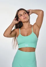 Conjunto deportivo compuesto por un top de tirantes finos con logo estampado y un short de tiro alto, ambos en tejido de punto sin costuras color verde menta.
