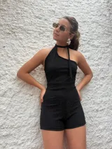 Mono corto negro de lurex con escote halter asimétrico y choker integrado.