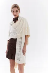 Ruana de punto color beige con detalles texturizados y tramados abiertos, ligera y versátil.