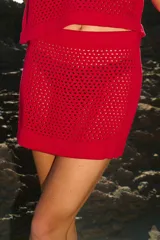 Minifalda tejida calada color rojo, de corte acampanado y cintura elastizada.