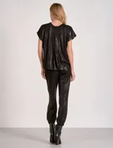 Enterito de silueta relajada confeccionado en tejido suave con lurex, color negro. Diseño de mangas cortas con escote a la base y laterales abiertos. Cintura elastizada y pantalón estilo jogger con terminación ajustada en el ruedo y bolsillos laterales.