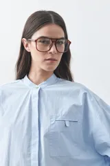 Camisa de manga larga en color celeste, con cuello mao y cierre frontal oculto. Presenta un diseño de silueta relajada con sisa caída y un bolsillo aplicado en el pecho.