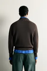 Jersey de punto tejido en hilatura de algodón con cuello en pico y manga larga, de corte regular fit y acabados en rib.