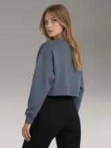 Buzo tipo fleece color azul grisáceo, con cuello redondo, corte regular y logo de Calvin Klein bordado en el pecho.