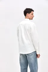 Camisa de corte regular fit confeccionada en algodón, con cuello clásico, cierre frontal de botones y bolsillo en el pecho con detalle bordado.