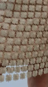 Pollera corta de encaje con diseño de flores caladas y destellos de lurex, con forro interior al tono.