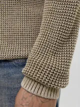Sweater de punto color tostado con cuello alto y medio cierre frontal con botones. Presenta mangas largas con puños acanalados y diseño de tejido texturizado.