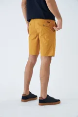 Bermuda tipo chino de gabardina, con bolsillos laterales y traseros, cierre de cremallera y botón, y pasacintos en la cintura. Presenta un diseño clásico con logo bordado.