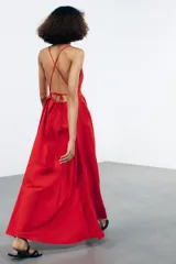 Vestido largo rojo de Zara Woman Collection confeccionado en hilatura con mezcla de algodón. Escote pico y tirantes finos cruzados en la espalda ajustable con lazadas. Tiene bolsillos laterales, detalle de pliegues en la cintura y cierre en la espalda con cremallera oculta en la costura.