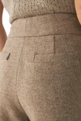Pantalón de tiro alto y pierna recta color marrón, con bolsillos laterales y presillas para cinto.