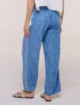 Pantalón wide leg de lyocell color azul con estampado paisley, cintura elástica y bolsillos laterales. Cuenta con una tira lateral decorativa con diseño ornamental.