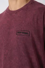 Remera de algodón peinado con efecto de lavado snow que le otorga un aspecto gastado. Presenta un diseño de cuello redondo, mangas cortas y un pequeño estampado gráfico en el pecho.
