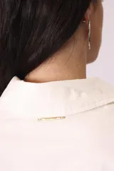 Camisa celeste de corte amplio, con cuello clásico, mangas largas y bolsillo en el pecho.