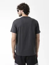 Remera gris oscuro de manga corta con estampado gráfico lineal de montañas en el frente.