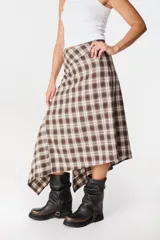 Falda midi de corte asimétrico con diseño de rayas horizontales en blanco y negro. Confeccionada en tejido satinado con caída fluida.