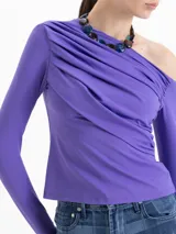 Top de manga larga color violeta, con diseño asimétrico de un solo hombro y detalle de drapeado frontal. Confeccionado en tejido de punto con acabado brillante.