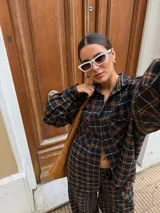 Pantalón de corte recto y holgado, confeccionado en tela de viyela con estampado de cuadros en tonos negro, gris y blanco. Presenta cintura elástica para mayor comodidad.