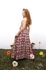 Falda larga de gasa con estampado tipográfico en color bordó sobre fondo beige. Presenta una silueta fluida y cierre lateral oculto.