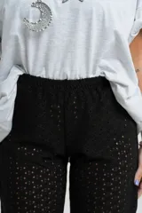 Pantalón negro de tejido calado con cintura elástica.
