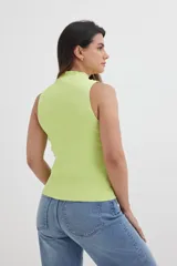 Top color beige de tejido de punto acanalado, sin mangas y con cuello alto.